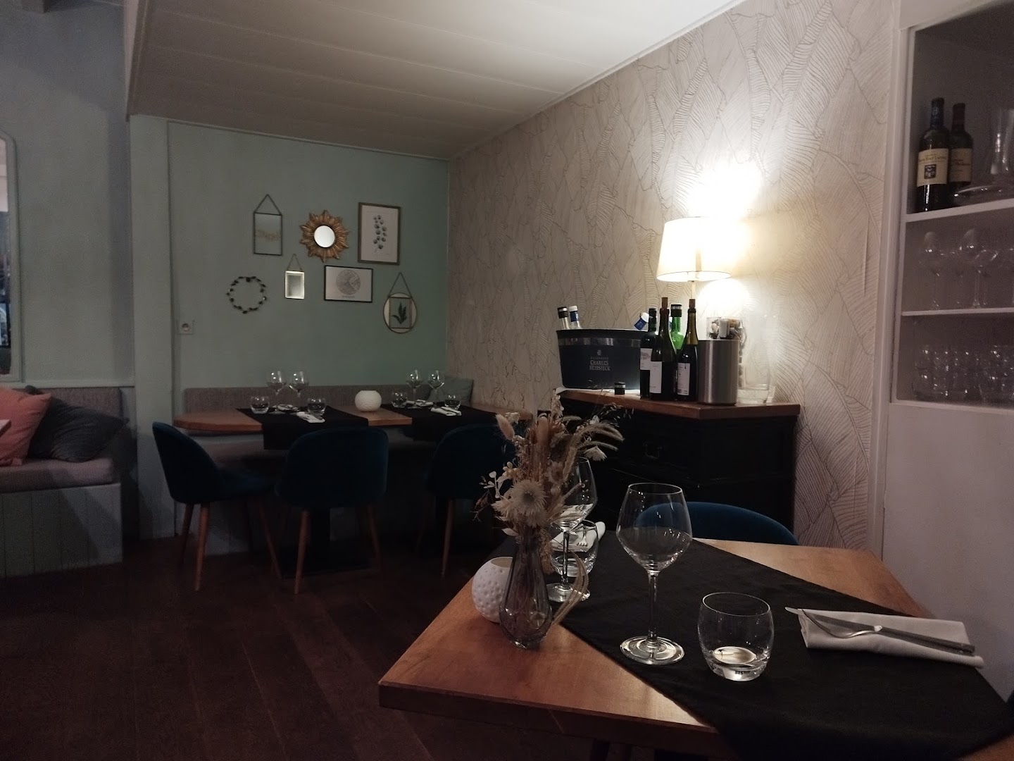 Une table dressée dans la salle claire aux fauteuils bleus